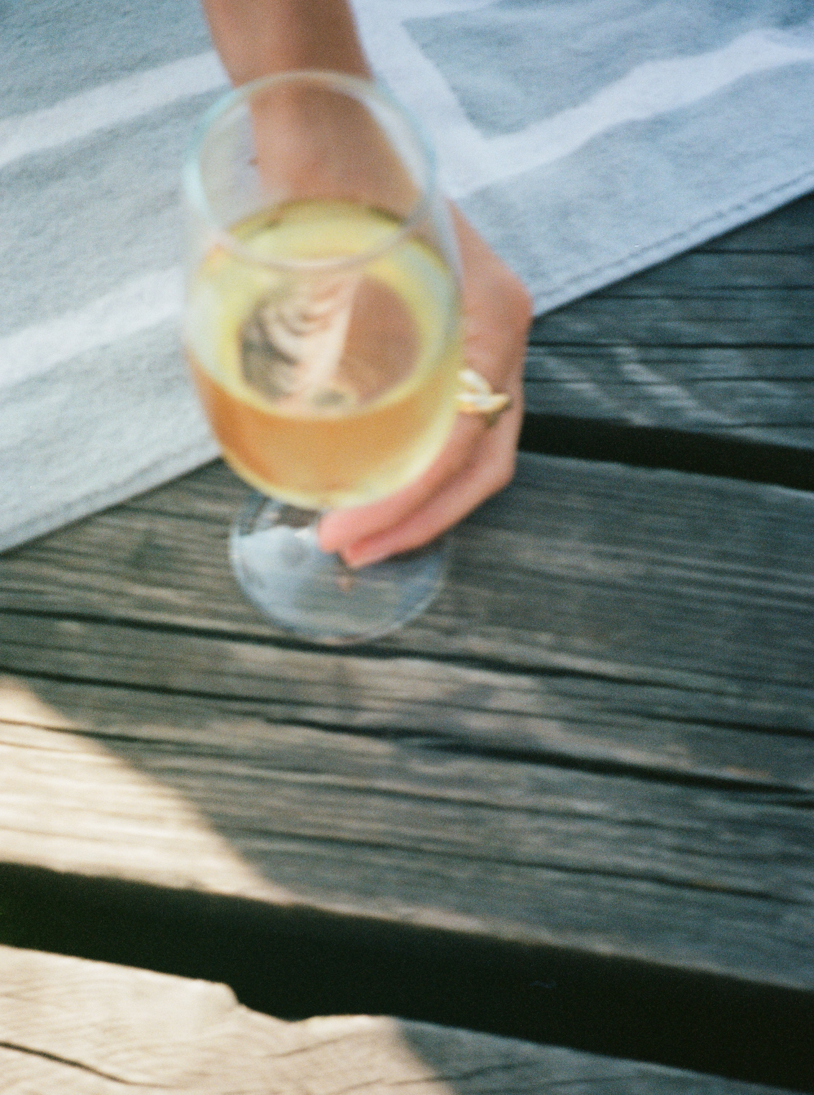 A glass of white accompanied by the Sofie Ring in gold